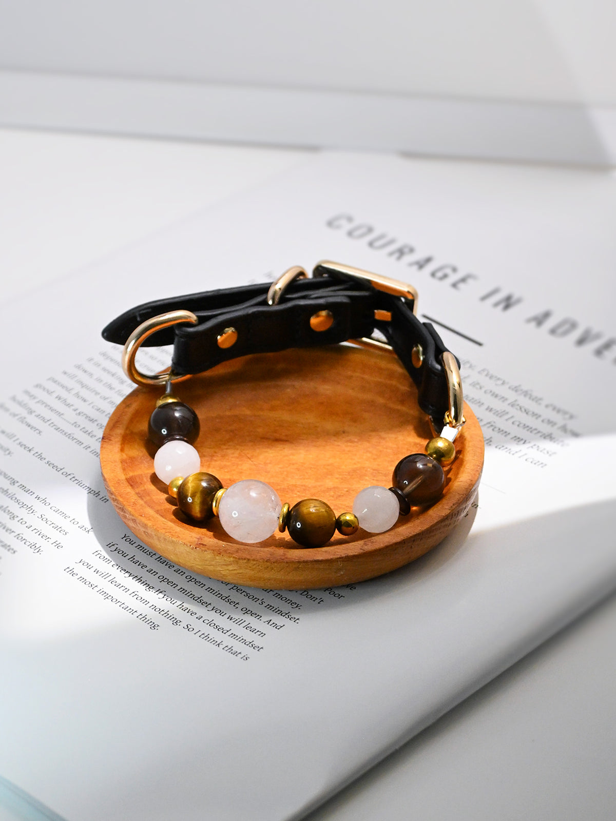 SoulBond Old Money Crystal Beaded Cat Collar displayed on a round wooden tray over an open book