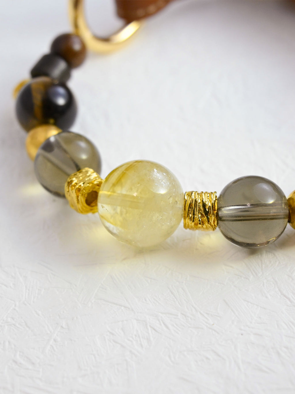 SoulBond Crystal Beaded Pet Collar close-up of a pale yellow center bead between smoky gray beads and textured gold-tone spacers