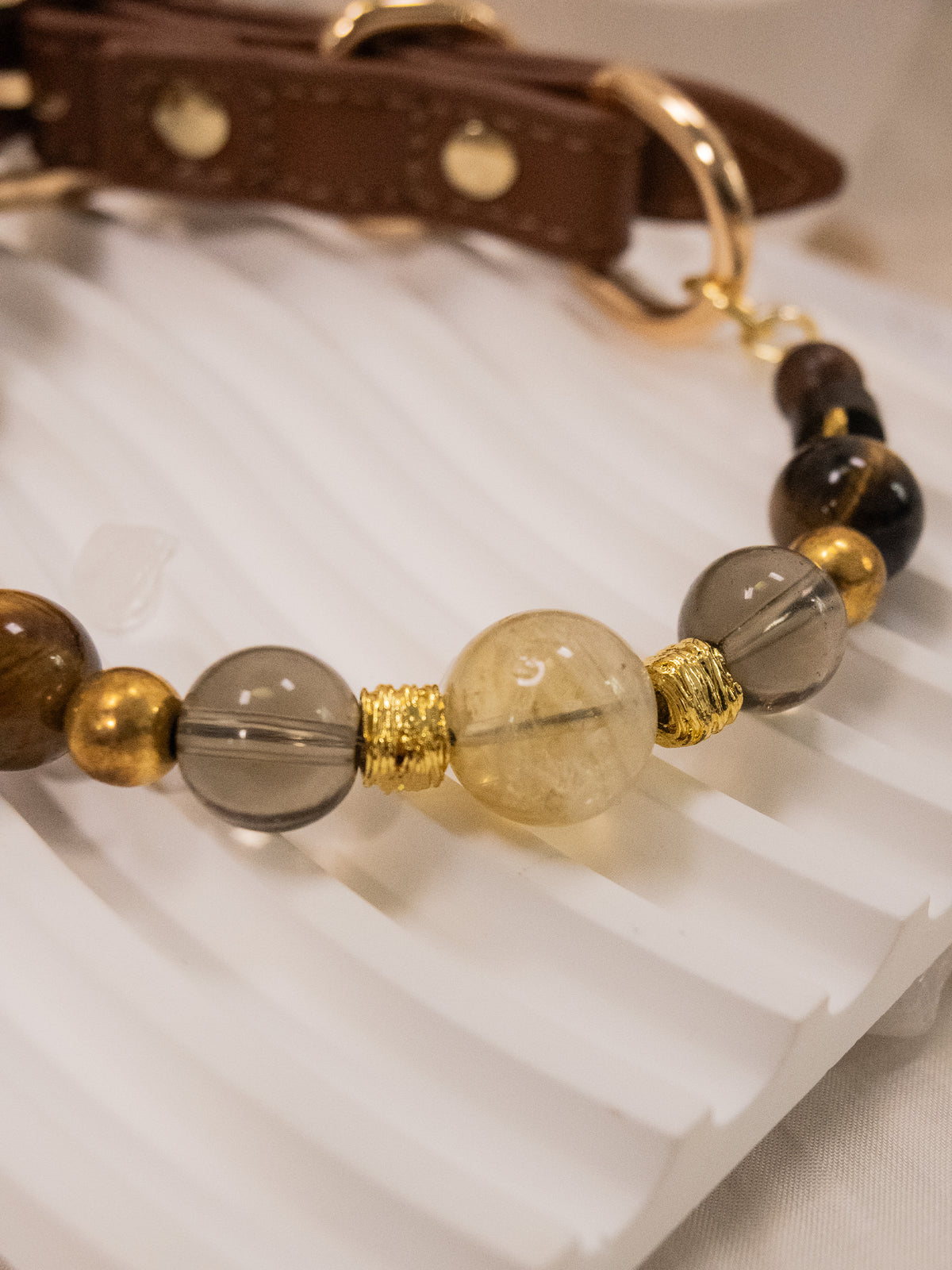 SoulBond Crystal Beaded Pet Collar showing translucent yellow and smoky gray beads on a white grooved tray