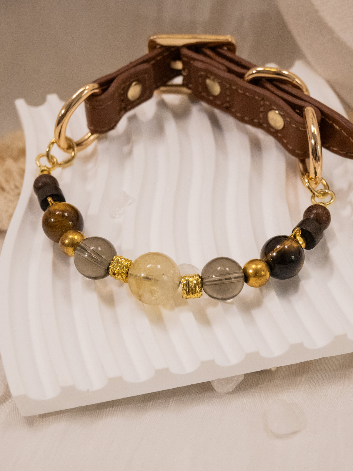 SoulBond Crystal Beaded Pet Collar with a brown strap and yellow, gray and brown beads arranged on a white display tray