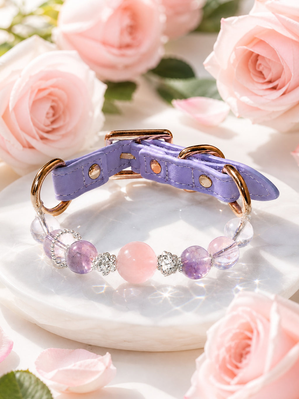 SoulBond Princess Crystal Cat Collar with pink and purple beads displayed on a round white slab surrounded by pink roses