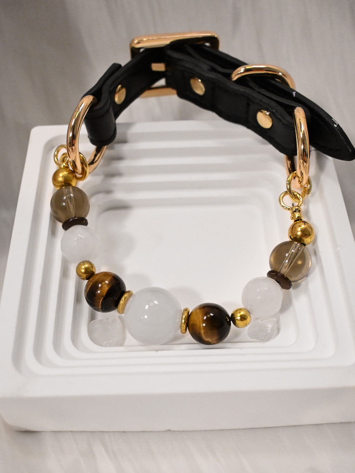 SoulBond Old Money Crystal Beaded Cat Collar with a black strap and white and brown beads displayed on a white square tray