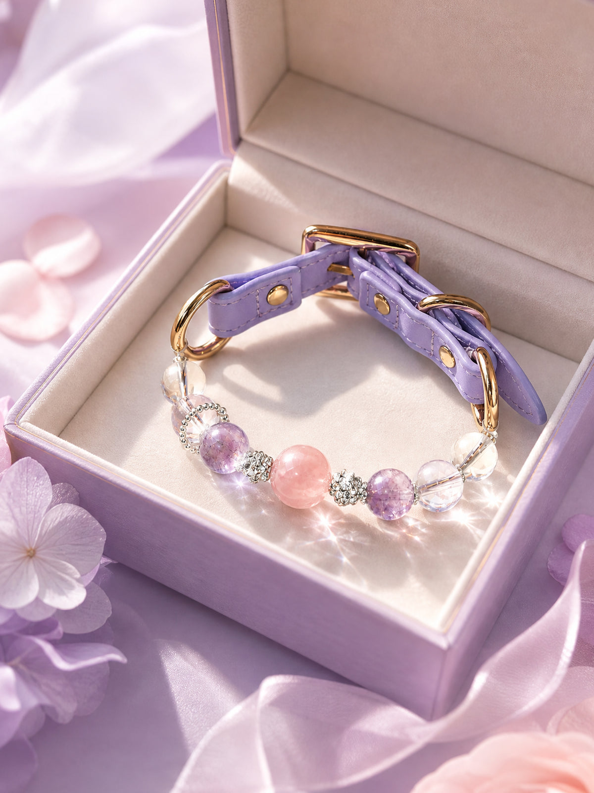 SoulBond Princess Crystal Cat Collar displayed inside an open lavender gift box beside purple flowers and ribbon