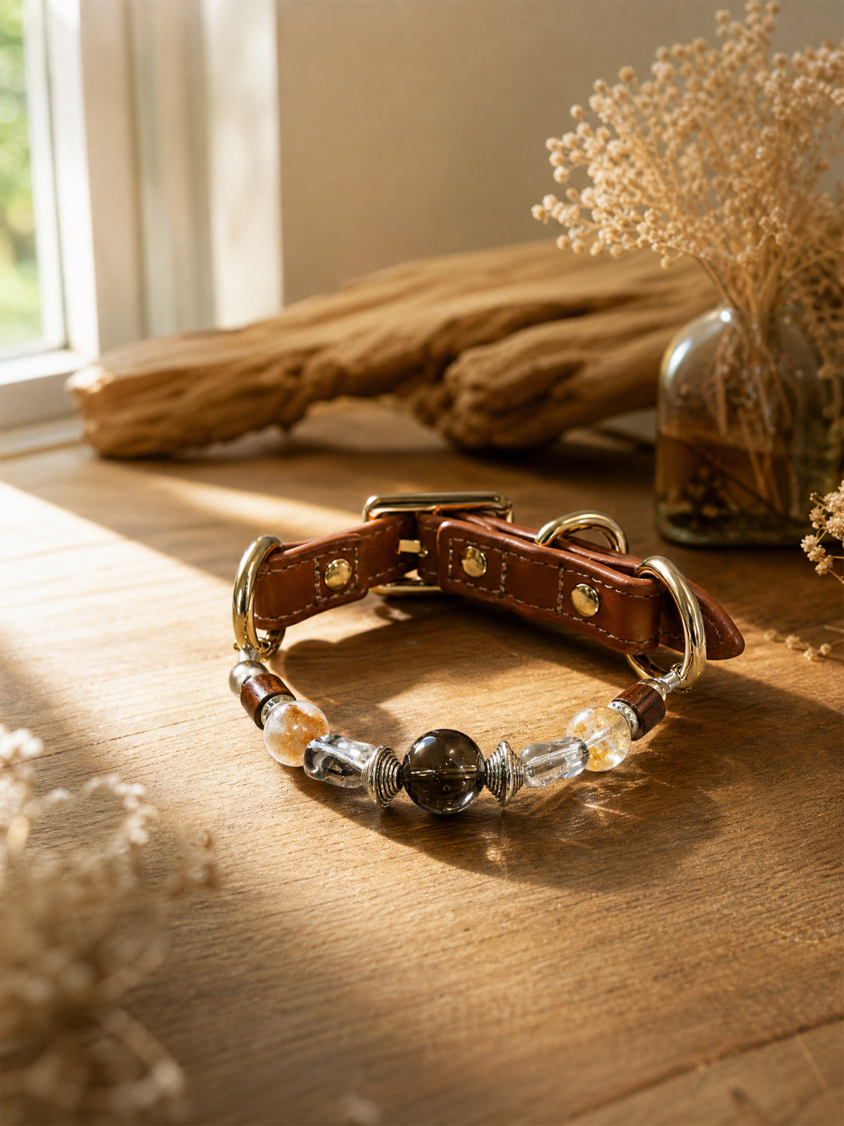 SoulBond Vintage Crystal Cat Collar on a sunlit wooden table beside driftwood and a vase of dried flowers