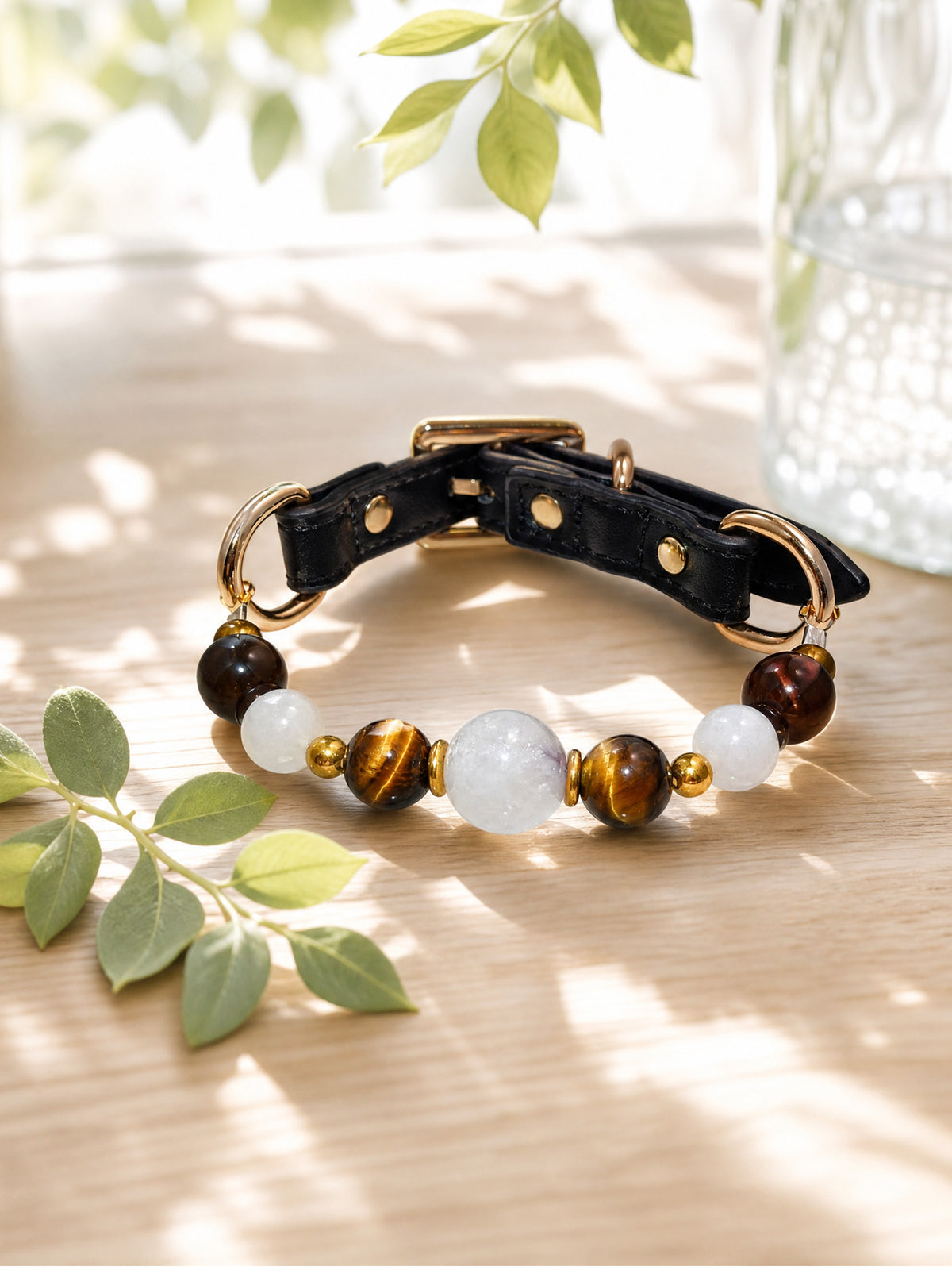 SoulBond Old Money Crystal Beaded Cat Collar on a sunlit wooden surface beside green leaves and a clear vase