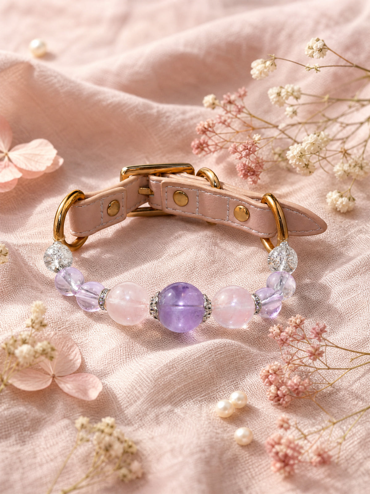SoulBond Crystal Charm Pet Collar with pink and purple beads on pink fabric beside small flowers