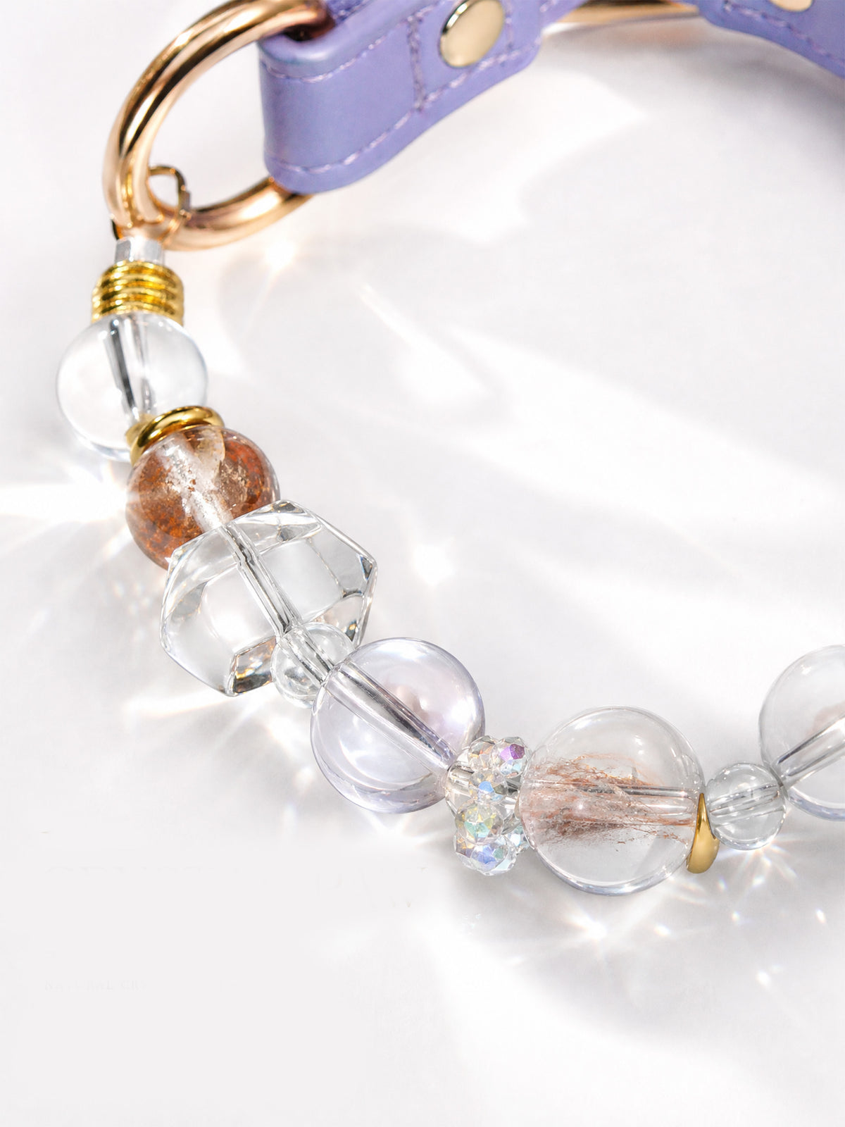 SoulBond White Crystal Cat Collar detail showing clear beads, faceted spacers and a gold-tone ring attached to the lavender strap