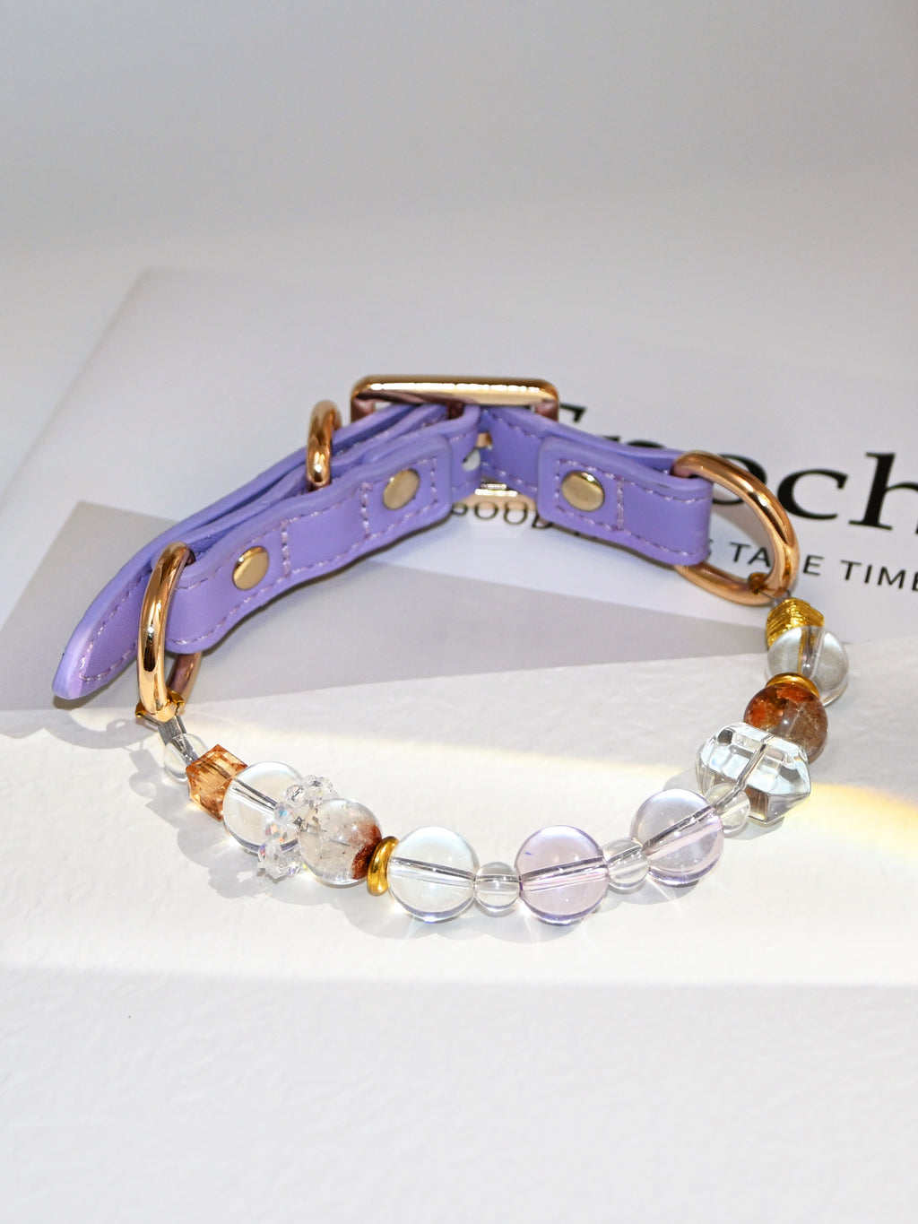 SoulBond White Crystal Cat Collar displayed on a printed page with clear round beads and amber-colored accents