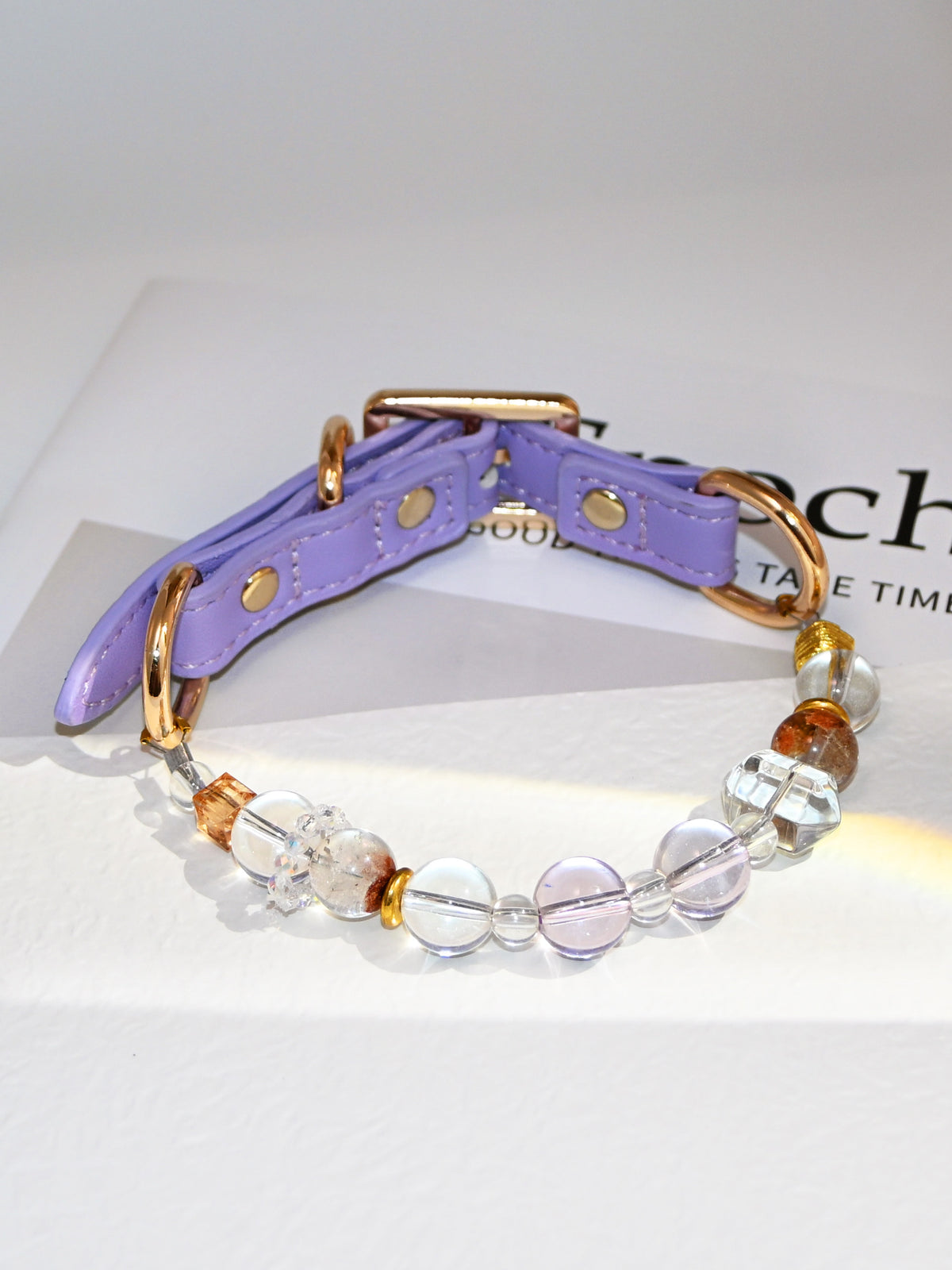 SoulBond White Crystal Cat Collar displayed on a printed page with clear round beads and amber-colored accents